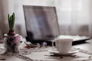 Getting ready to work with an open laptop and a steaming cup of tea